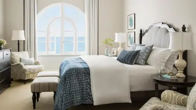 a bedroom with a bed and a chair and a window at Casa Del Mar in Los Angeles