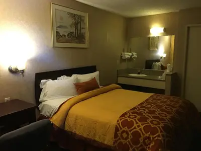 a hotel room with a bed and a sink at Executive Suites Inn in Westminster