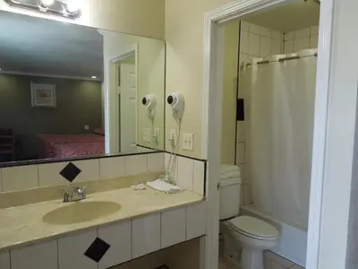 a bathroom with a sink and a toilet and a mirror at Castaway Motel in Orange