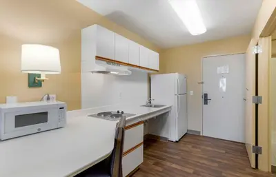 a kitchen with a white microwave and a refrigerator at Extended Stay America Suites - Orange County - Cypress in Cypress