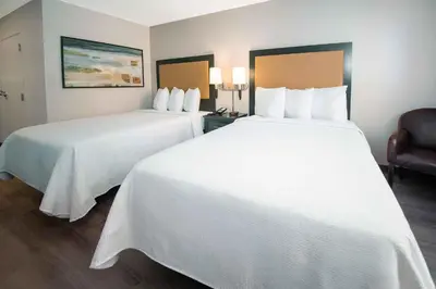 two beds in a hotel room with white sheets at Extended Stay America Suites - Los Angeles - Torrance - Del Amo Circle in Torrance