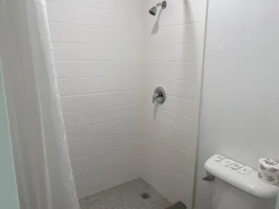 a white shower with a toilet in a bathroom at Regency Motel in Brea