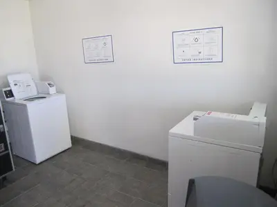 a laundry room with a refrigerator and a washer and dryer at Motel 6-Anaheim, CA in Anaheim