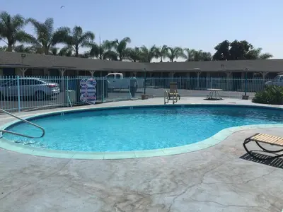 a large swimming pool with blue water in a yard at Frontier Motel in Anaheim