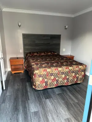 a bedroom with a large bed and a wooden floor at Vegas motel in West Athens