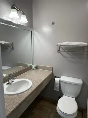 a bathroom with a sink and a toilet and a mirror at Vegas motel in West Athens