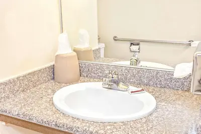 a bathroom counter with a sink and a mirror at Vantage Point Inn - Woodland Hills in Woodland Hills