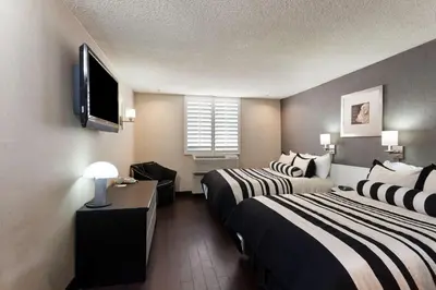a hotel room with two beds and a flat screen tv at Ramada Plaza by Wyndham West Hollywood Hotel & Suites in Los Angeles