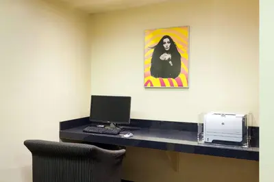 a room with a desk with a computer and a picture at Ramada Plaza by Wyndham West Hollywood Hotel & Suites in Los Angeles