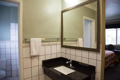 a bathroom with a sink and a mirror at Sahara Motel in Anaheim
