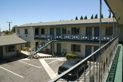 a building with a car parked in a parking lot at Sahara Motel in Anaheim