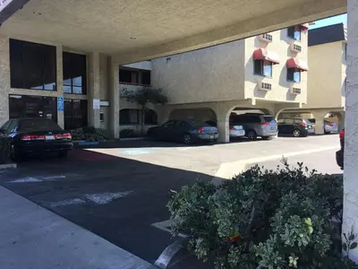 a parking lot with cars parked in front of a building at Grand Inn\u8ca1\u795e\u5ba2\u68e7 in Monterey Park