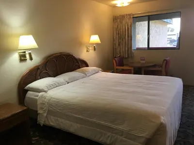 a hotel room with a large bed and a table at Grand Inn\u8ca1\u795e\u5ba2\u68e7 in Monterey Park