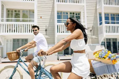 a woman in a white dress riding a bike at Shutters On The Beach in Los Angeles