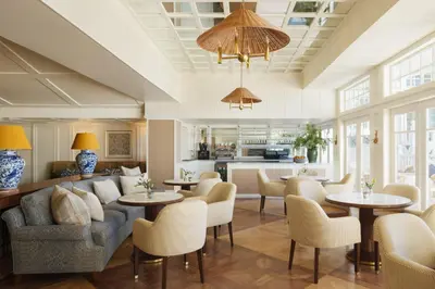 a living room with a couch and tables and chairs at Shutters On The Beach in Los Angeles