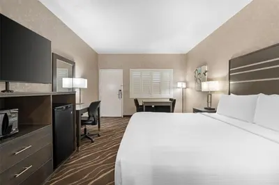 a hotel room with a large bed and a desk at Best Western Plus Park Place Inn - Mini Suites in Anaheim
