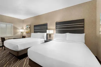 a hotel room with two beds and a desk at Best Western Plus Park Place Inn - Mini Suites in Anaheim