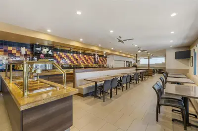 a restaurant with a bar with tables and chairs at Best Western Plus Park Place Inn - Mini Suites in Anaheim