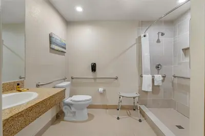a bathroom with a toilet and a sink and a shower at Best Western Plus Park Place Inn - Mini Suites in Anaheim