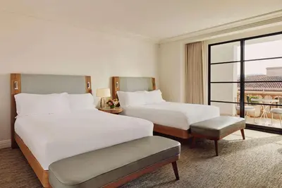 a hotel room with two beds and a large window at The Maybourne Beverly Hills, Maybourne in Los Angeles
