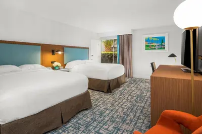 a hotel room with two beds and a desk at Anaheim Hotel in Anaheim