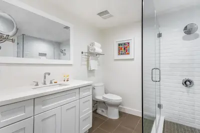 a white bathroom with a toilet and a shower at Anaheim Hotel in Anaheim
