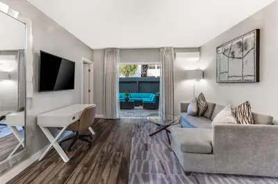 a living room with a couch and a desk at Anaheim Hotel in Anaheim