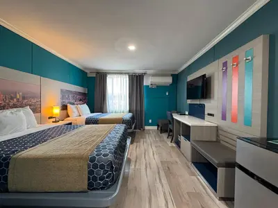 a hotel room with two beds and a desk at Hometel Suites in Los Angeles