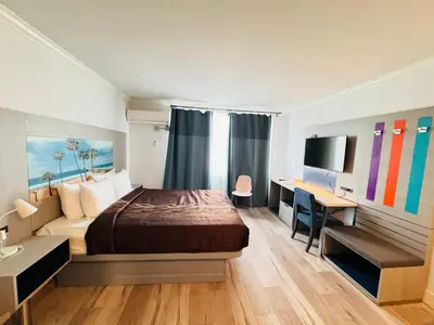 a hotel room with a bed and a desk and a desk at Hometel Suites in Los Angeles