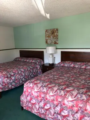 a hotel room with two beds and a lamp at King Lodge Motel in Monterey Park
