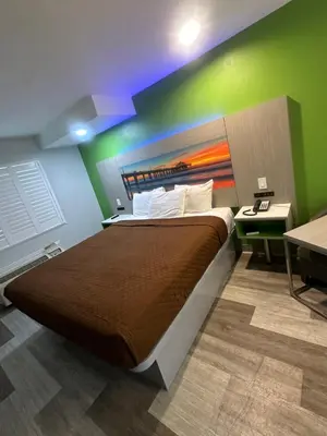 a bedroom with a large bed with a green wall at Garden Inn San Gabriel in San Gabriel