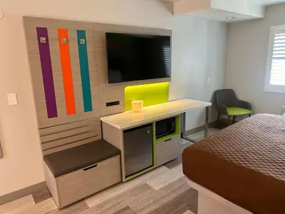 a room with a bed and a desk with a television at Garden Inn San Gabriel in San Gabriel