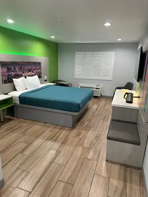a hotel room with a bed and a desk and a desk at Garden Inn San Gabriel in San Gabriel