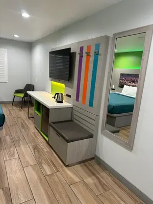a room with a desk and a bed and a mirror at Garden Inn San Gabriel in San Gabriel