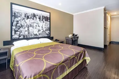 a hotel room with a bed and a large painting on the wall at Super 8 by Wyndham North Hollywood in North Hollywood