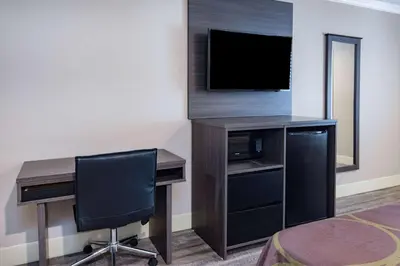 a room with a desk with a computer and a television at Super 8 by Wyndham North Hollywood in North Hollywood