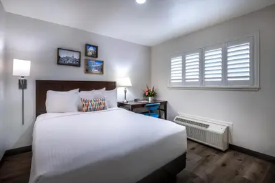 a bedroom with a large white bed and a window at Alpine Inn near Convention Center and the Park in Anaheim
