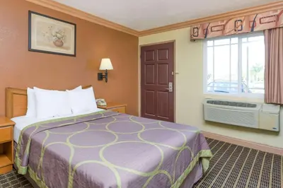 a hotel room with a bed and a window at Super 8 by Wyndham Azusa in Azusa