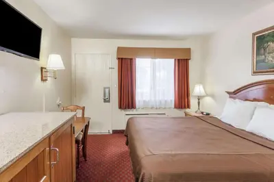 a hotel room with a large bed and a window at Travelodge Inn & Suites by Wyndham Fullerton in Fullerton