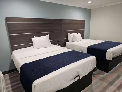 two beds in a hotel room with two beds at Travelodge Inn & Suites by Wyndham Fullerton in Fullerton
