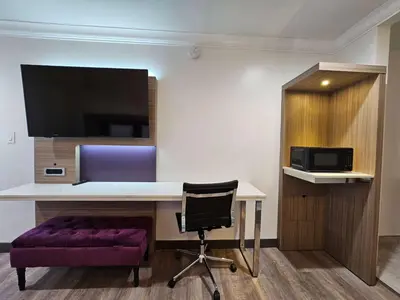 a desk with a purple chair in a room at Travelodge Inn & Suites by Wyndham Fullerton in Fullerton