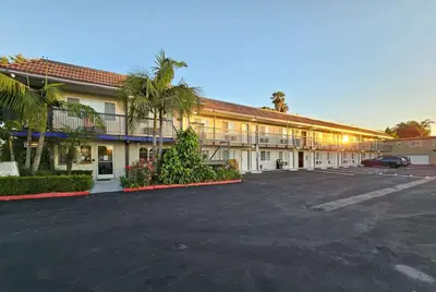 a building with a parking lot in front of it at Travelodge Inn & Suites by Wyndham Fullerton in Fullerton