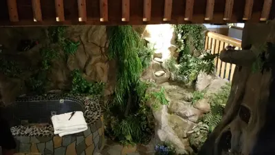 a view of a garden with a rock wall at Castle Wood Theme Cottages- COUPLES ONLY in Big Bear Lake
