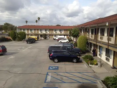 a parking lot with cars parked in front of a motel at Fullerton Inn in Fullerton
