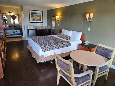 a hotel room with a bed and a table at Fullerton Inn in Fullerton