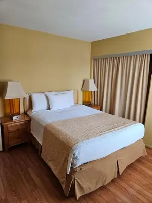 a bedroom with a large bed and two night stands with lamps at Fullerton Inn in Fullerton