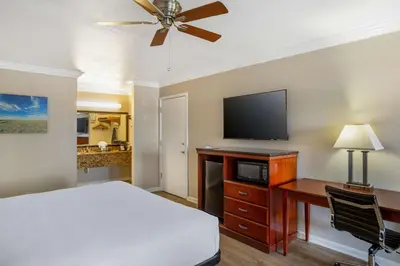 a bedroom with a bed and a desk and a tv at Best Western Heritage Inn in Bakersfield
