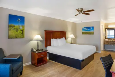 a hotel room with a bed and a chair at Best Western Heritage Inn in Bakersfield