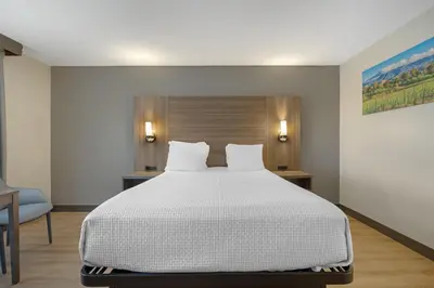 a bedroom with a large bed and a chair at Best Western La Posada Motel in Fillmore