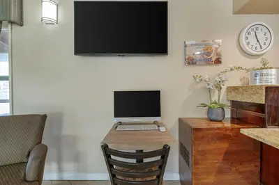 a desk with a computer and a monitor on a wall at Best Western La Posada Motel in Fillmore